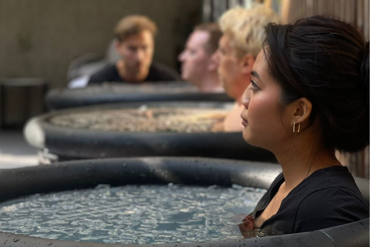 Lady practicing breathwork exercises while fully submerged in an ice bath at a wellness experience event of Fit by David.