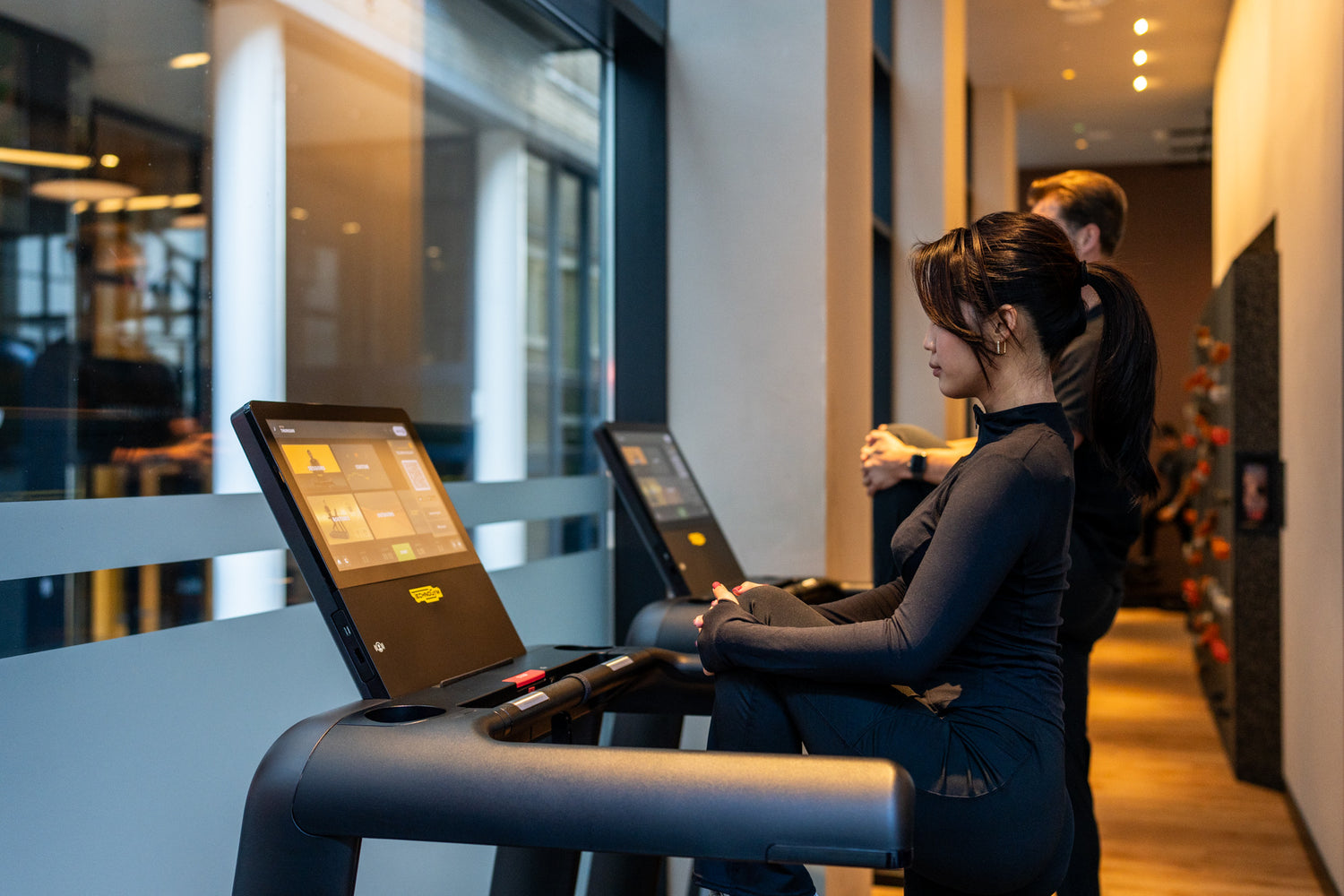 Female client warming up on treadmill with digital display during a personal training session at Fit by David gym in Amsterdam, focused on cardio training, weight loss, and fitness coaching.