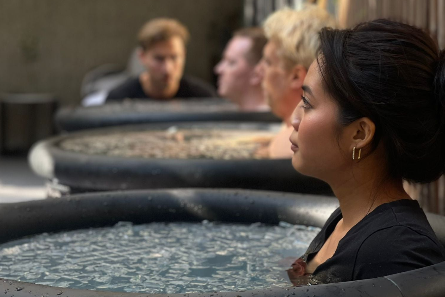 Lady practicing breathwork exercises while fully submerged in an ice bath at a wellness experience event of Fit by David.